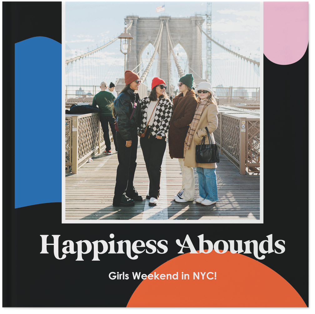 A black photo album with white text, a photo of four women, and colorful shapes